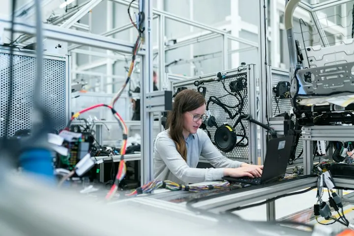 Engineer working next to an industrial robot arm